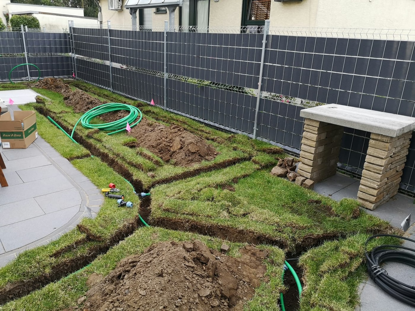 Verlegte Bewässerungsleitungen in offenen Gräben entlang der Terrasse