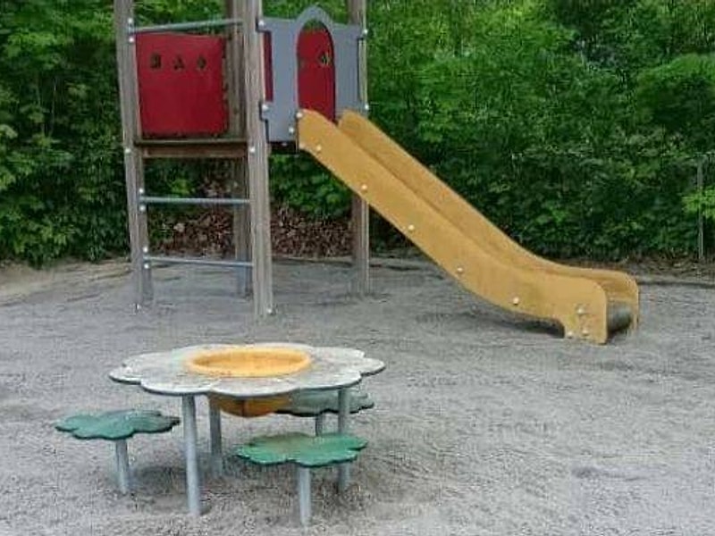 Spielturm mit Rutsche und Spieltisch auf neuem Sandbett