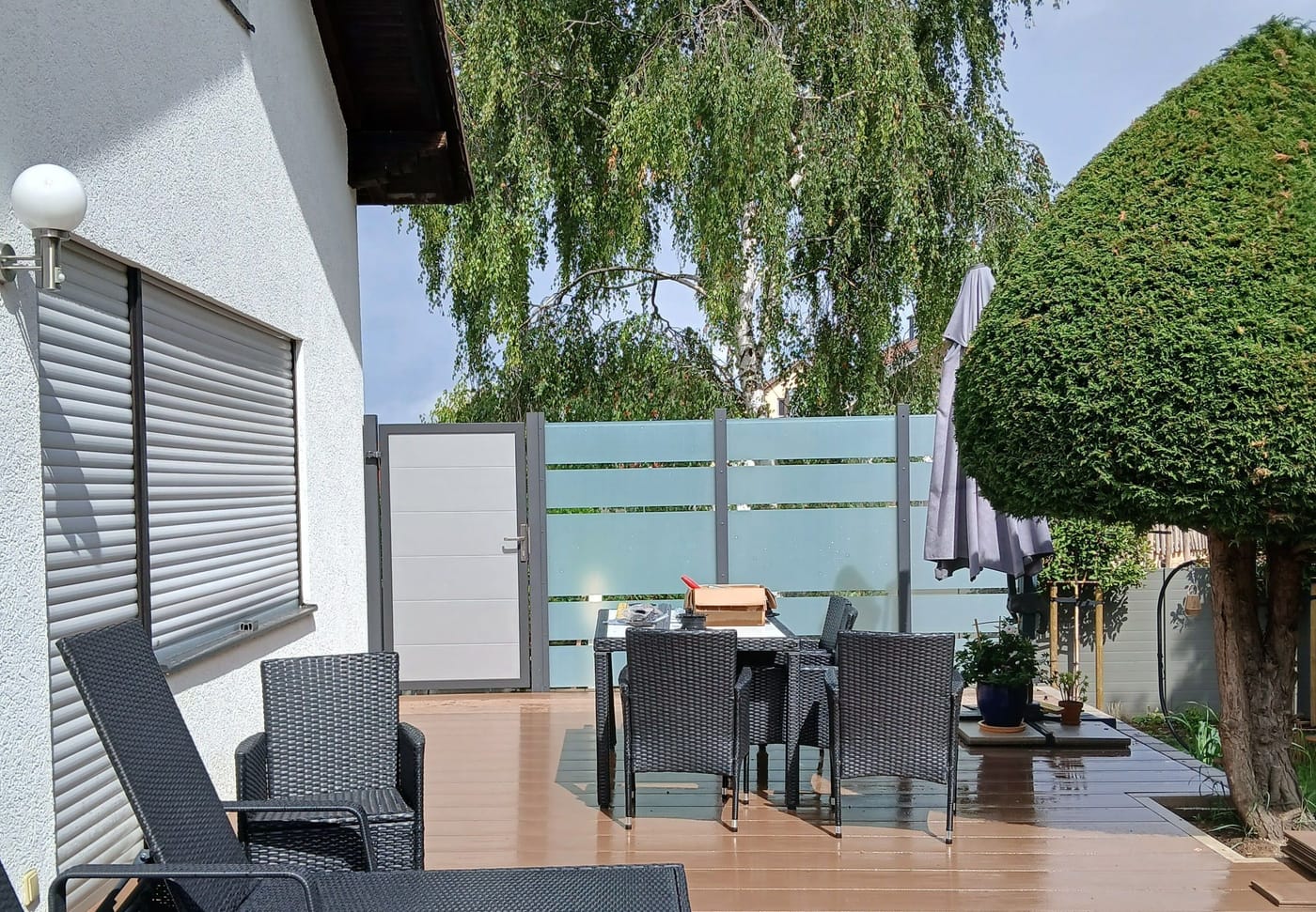 Fertige WPC-Terrasse mit Sitzgruppe und Sichtschutzwand