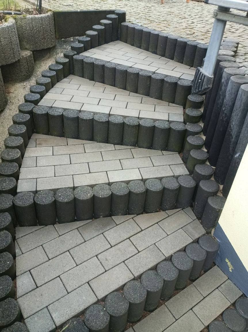 Gewendelte Treppe aus Rundpalisaden mit Pflasterbelag